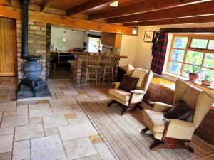- un salon avec des chaises et un poêle à bois dans l'établissement Loch Lomond shore Boat House, à Balmaha