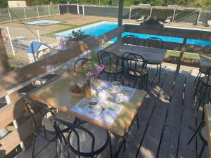 a table and chairs on a deck next to a pool at Camping La Bernede in Rennes-les-Bains