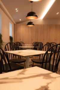 une rangée de tables et de chaises dans un restaurant dans l'établissement Nomad Hotel Paralia, à Paralia Katerinis