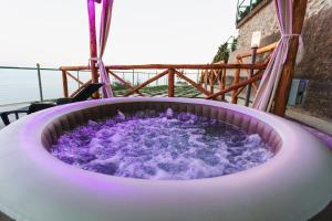 una vasca idromassaggio con acqua viola su uno scivolo di Apartments PARADISE GARDEN Holiday House ad Agerola