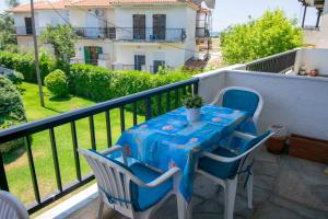 a table and chairs sitting on a balcony at Esperida Apartment by RentalsPro - Fourka Beach Halkidiki in Skala Fourkas