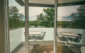 ein Balkon mit zwei Tischen und Stühlen auf einer Terrasse in der Unterkunft Hôtel-Restaurant Casa 49 in Remich