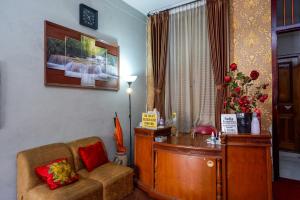 RedDoorz At Golden Inn Tugu Yogyakarta في يوغياكارتا: غرفة معيشة مع مكتب وأريكة