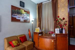 a living room with a desk and a couch at RedDoorz At Golden Inn Tugu Yogyakarta in Yogyakarta