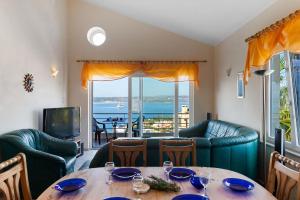 a dining room with a table and a view of the ocean at Villa Diana BY APOKORONAS-VILLAS in Plaka