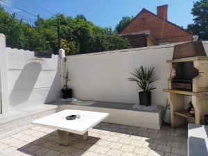 a patio with a white fence and a table at Maison confortable à Lens proche du centre et du stade in Lens