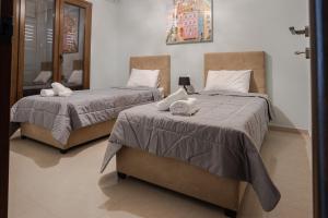 two beds sitting next to each other in a bedroom at Luxury Sweet Home in Agria