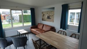 a living room with a couch and a table at Camping de Duinhoeve Chalet Schelp not for companies in Nieuw-Haamstede