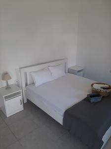 a bedroom with a large white bed and a night stand at Villa Giotis Suite in Skala Sotiros