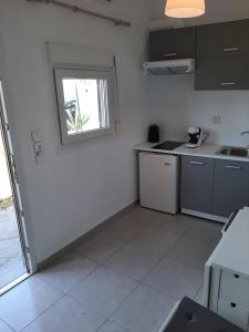 a white kitchen with a sink and a window at Villa Giotis Suite in Skala Sotiros