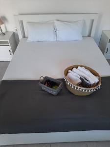 a bed with a bowl of towels and a basket of towels at Villa Giotis Suite in Skala Sotiros