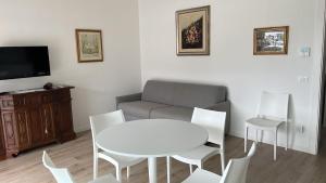 een woonkamer met een bank, een tafel en stoelen bij Apartment Lake Garda in Garda