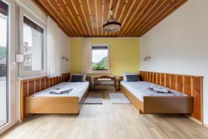 two beds in a room with two windows at Apartmaji Rupnik in Bohinjska Bistrica