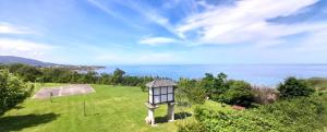 latarnia na polu z oceanem w tle w obiekcie Apartamento Rural Playa Foz - VISTAS AL MAR w mieście Foz