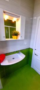 zieloną łazienkę z umywalką i lustrem. w obiekcie Apartamento Rural Playa Foz - VISTAS AL MAR w mieście Foz