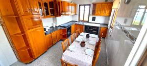 kuchnia ze stołem i krzesłami oraz kuchnia z drewnianymi szafkami w obiekcie Apartamento Rural Playa Foz - VISTAS AL MAR w mieście Foz +18 zdjęć