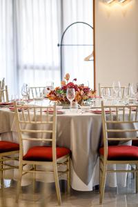 een lange tafel met stoelen en een witte tafelkleed bij LDS Hotel Belgrade in Belgrado