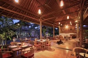un restaurant avec des tables et des chaises et un grand plafond dans l'établissement Chili Ubud Cottage, à Ubud