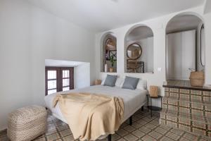 a bedroom with a large bed and two mirrors at Apartamentos Líbere Málaga la Merced in Málaga