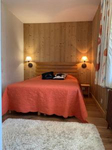 - une chambre avec un lit rouge, deux lampes et un tapis dans l'établissement Val Claret, Tignes T2 tout confort de 36m2, à Tignes
