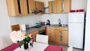 een keuken met een tafel met een vaas met bloemen bij Apartment and Room Bitinada in Rovinj