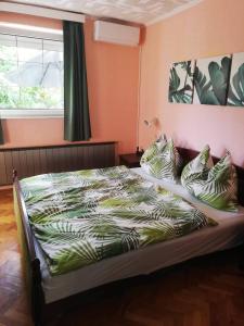 um quarto com uma cama com almofadas e uma janela em Oázis Apartman em Szántód