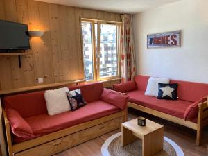 a living room with a red couch and a tv at Val Claret, Tignes T2 tout confort de 36m2 in Tignes