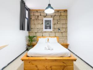 1 dormitorio con cama y pared de ladrillo en Cathedral Apartment, en Las Palmas de Gran Canaria