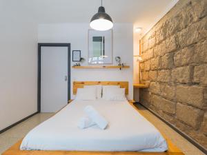 Un dormitorio con una gran cama blanca y una pared de ladrillo en Cathedral Apartment, en Las Palmas de Gran Canaria