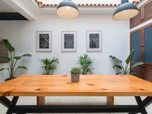 una mesa de madera en una habitación con plantas en Cathedral Apartment, en Las Palmas de Gran Canaria