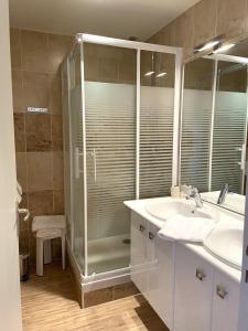 La salle de bains est pourvue d'une douche et d'un lavabo. dans l'établissement Hotel Beauséjour, à Vic-sur-Cère