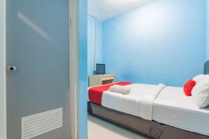 Dormitorio azul con cama y espejo en RedDoorz Syariah At Jl Pangeran Hidayatullah Cianjur, en Cianjur