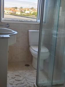 a bathroom with a toilet and a sink and a window at Casa Milia Orange in Marinhas
