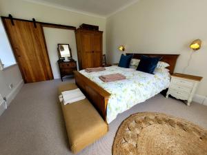 a bedroom with a large bed with a dresser and a mirror at Blair Cottage in Rowardennan