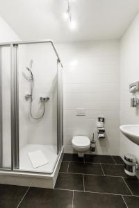 e bagno con doccia, servizi igienici e lavandino. di Familienapartment nahe der Frauenkirche a Dresda