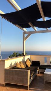 a couch on a balcony with a view of the ocean at SUNSET APARTMENTS in Évdhilos