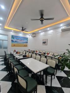 una sala de conferencias con mesas, sillas y una pantalla en ĐẠI THỦY Hotel en Cat Ba