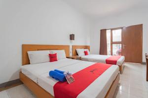Postel nebo postele na pokoji v ubytování RedDoorz Plus At Hotel Sofia Pangandaran + 37 fotografií