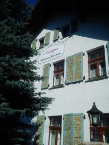 a white building with windows and a sign on it at Pensjonat Nostalgia in Sosnówka