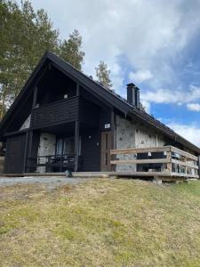 a large black and white building in a field at Himos Mökki in Jämsä