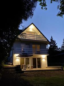 Casa grande con porche con sillas y sombrilla en Dom Dwa Jeziora - Augustów en Augustów