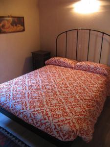 a bedroom with a bed with a red and white comforter at Casa Vacanze La Meridiana in Baceno