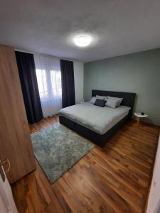 a bedroom with a bed and a wooden floor at apartman Magnolia in Sarajevo