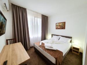 a hotel room with a bed and a table at Hotel Decebal Eforie Nord in Eforie Nord