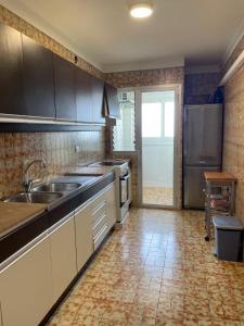 a kitchen with a sink and a refrigerator at Pinets in L'Ampolla