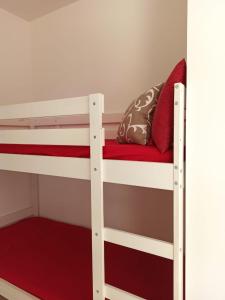 a bunk bed with a red pillow on top of it at appartamento martina in Scarlino