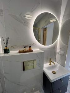 a white bathroom with a sink and a mirror at Grudza Barn House in Grudza