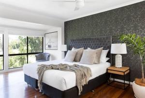 a bedroom with a large bed and a chair at Coral villa in Byron Bay +32 photos