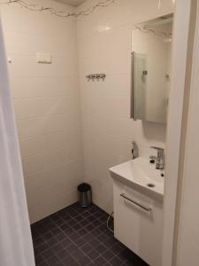 a white bathroom with a sink and a mirror at Adorable Central Apartment Helsinki in Helsinki