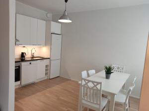 赫爾辛基的住宿－Adorable Central Apartment Helsinki，厨房以及带白色桌椅的用餐室。